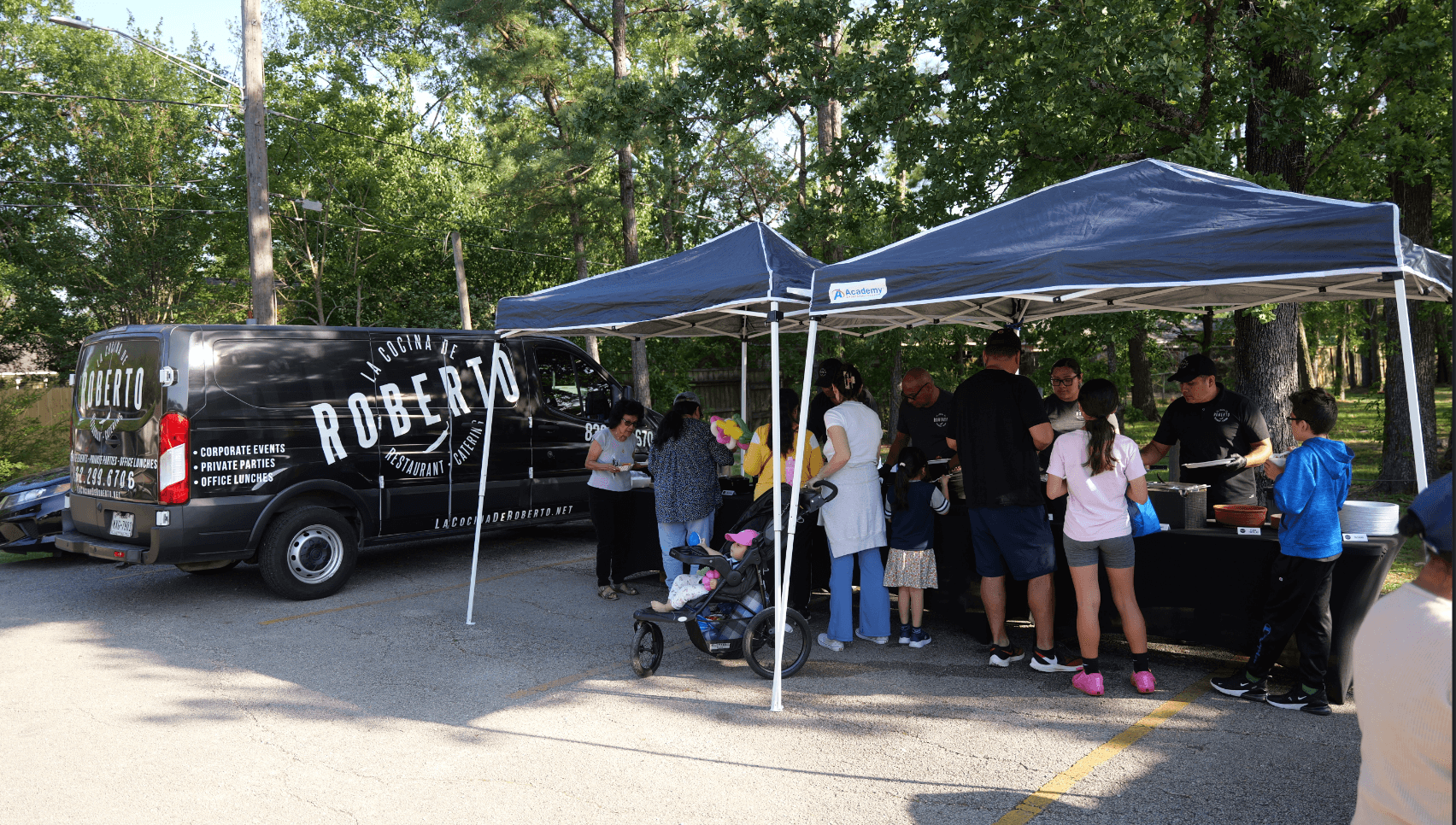 people standing under a tent for tacos